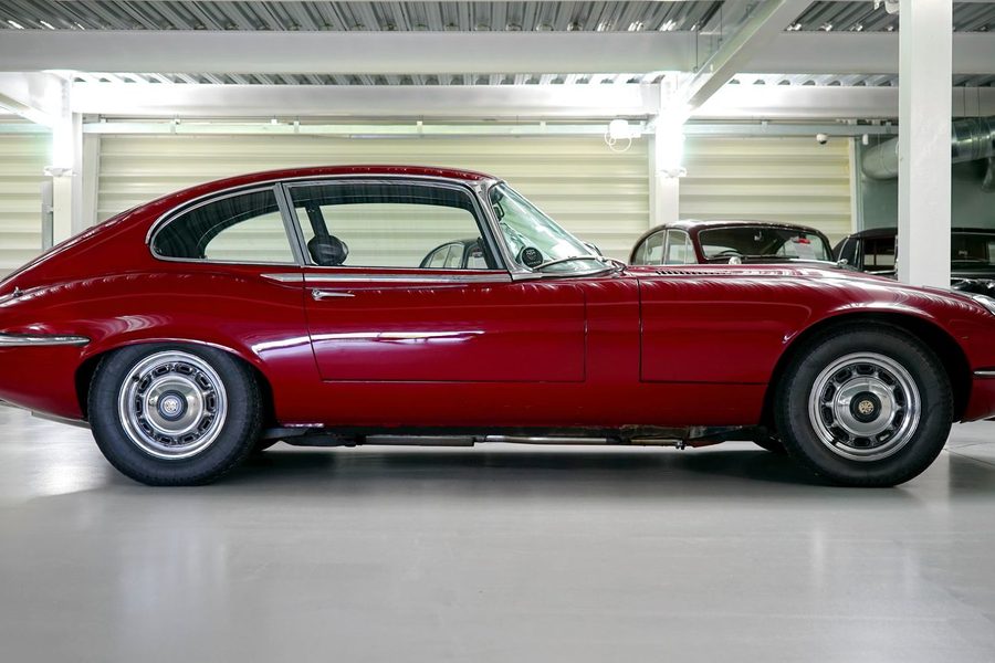 Dunkelrotes klassisches Coupé mit langer Haube in einer Werkstatthalle