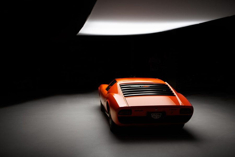 Heck eines orangen Mittelmotor-Klassikers unter einem Lichtkegel