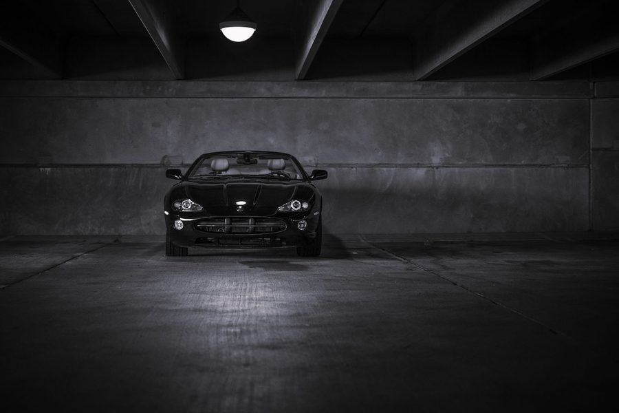 Dunkles Coupé frontal in einer Betongarage